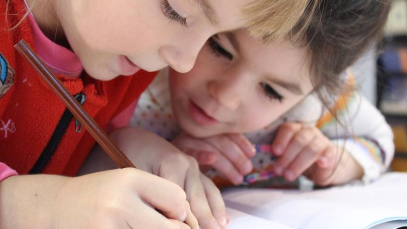 Two kids drawing with pencil